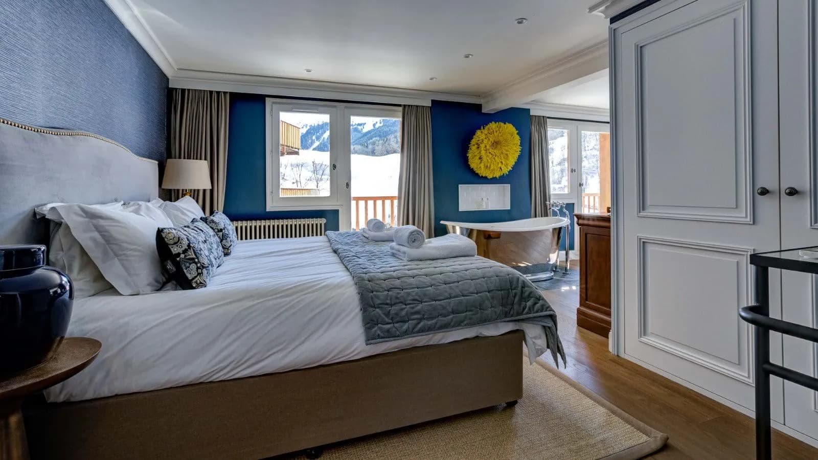 Primary bedroom with king bed and in-room soaking tub; mountain views