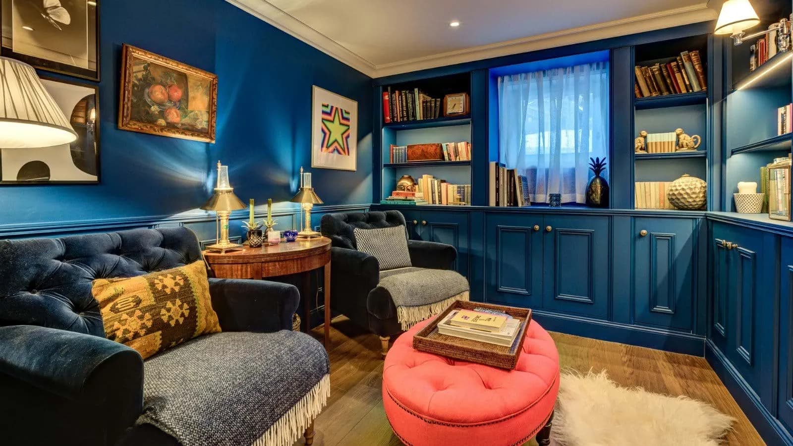 Library with floor-to-ceiling built-ins and velvet armchair seating