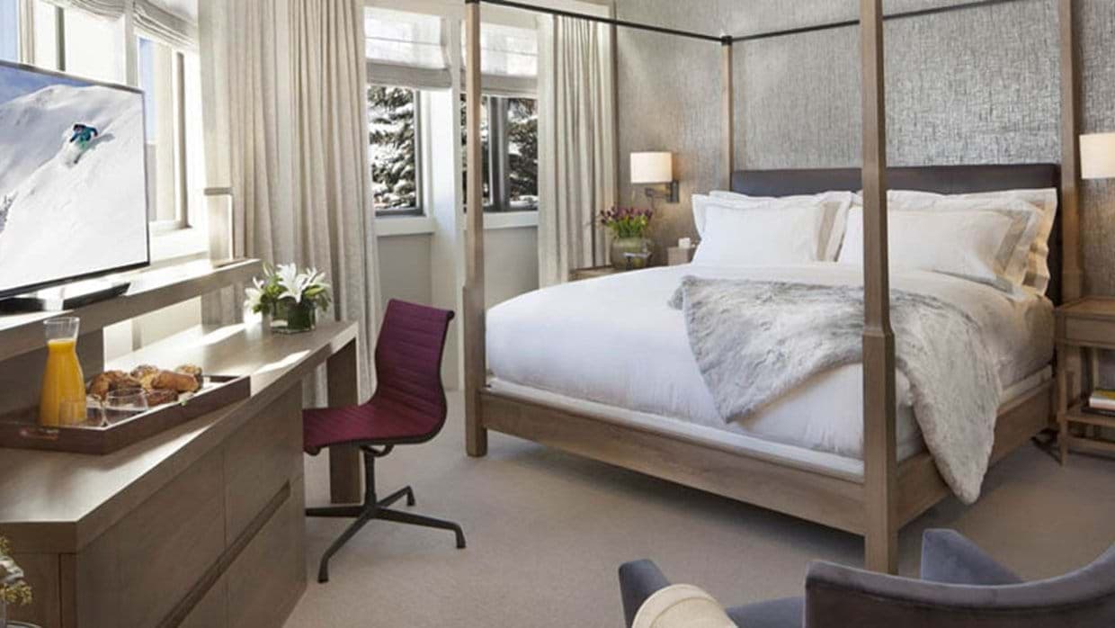 Primary bedroom with king poster bed and workspace; snow-covered views