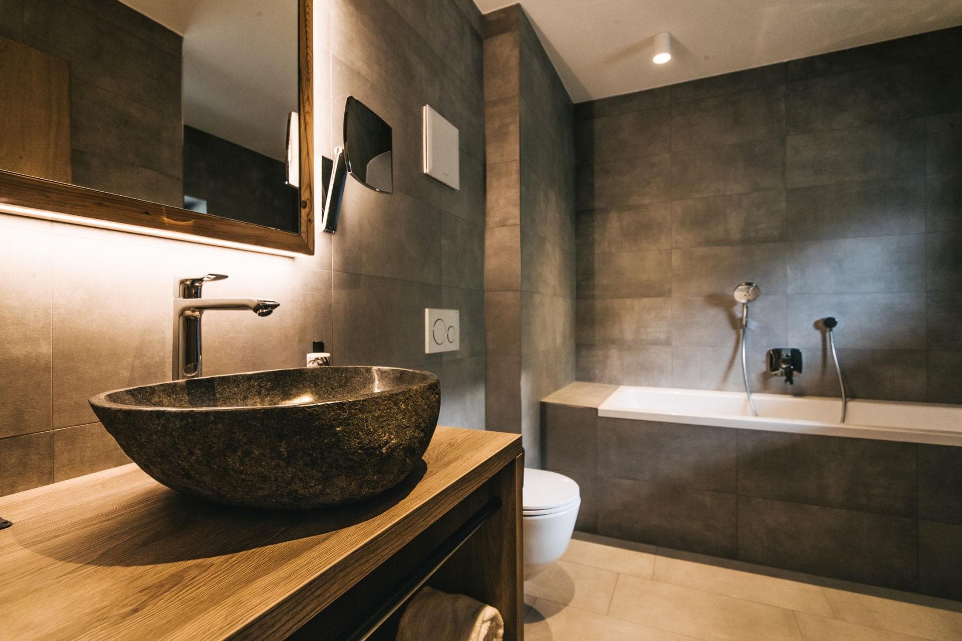 Bathroom with stone vessel sink, soaking tub, and handheld shower wand
