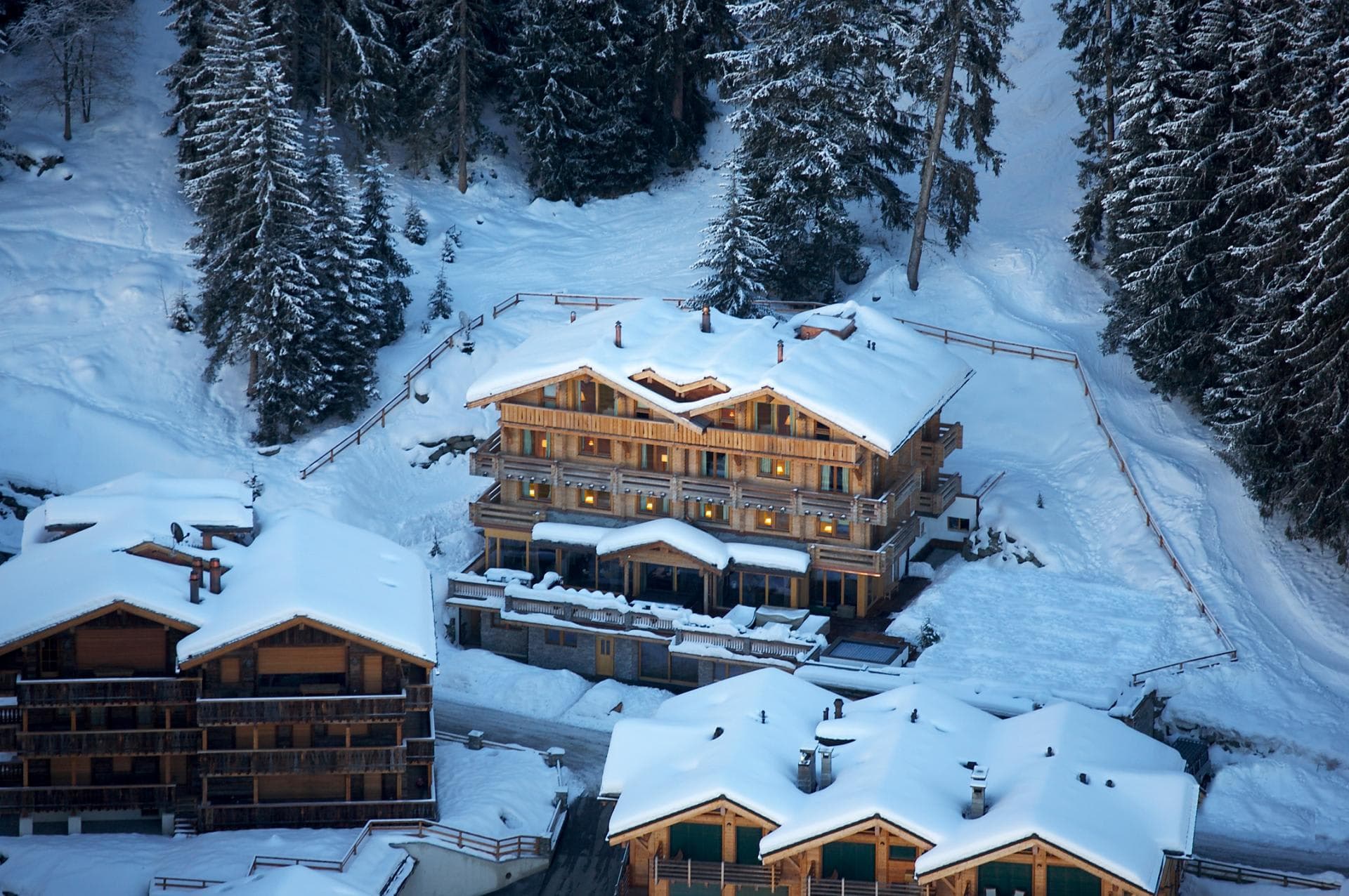 Ski-in, ski-out timber chalet with multiple balconies and forest backdrop