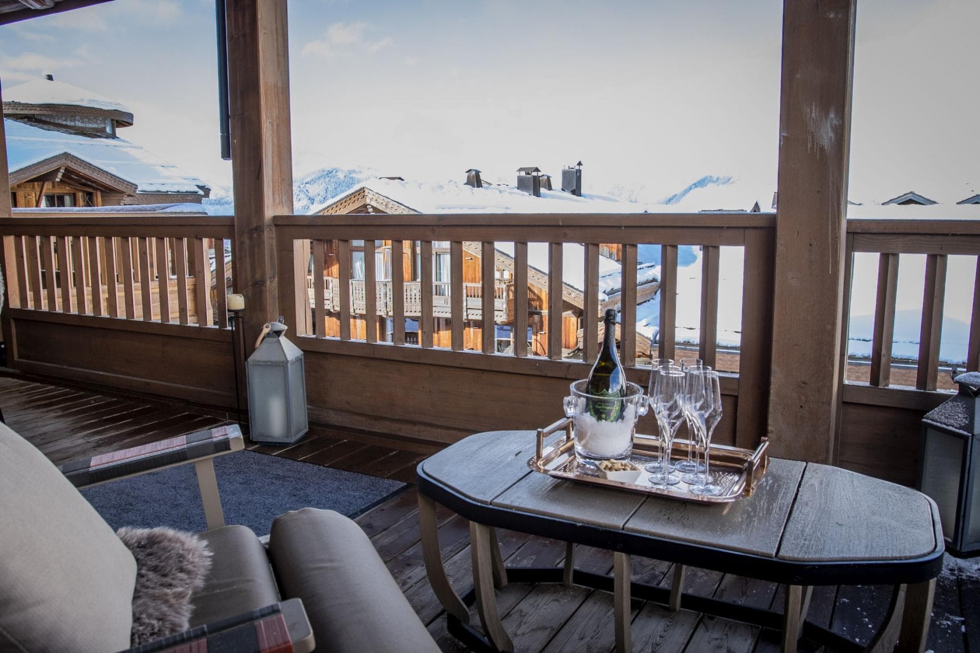 Covered timber balcony with lounge seating and alpine village views