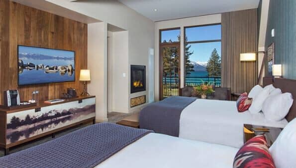 Guest room with two queen beds, gas fireplace, and lake views