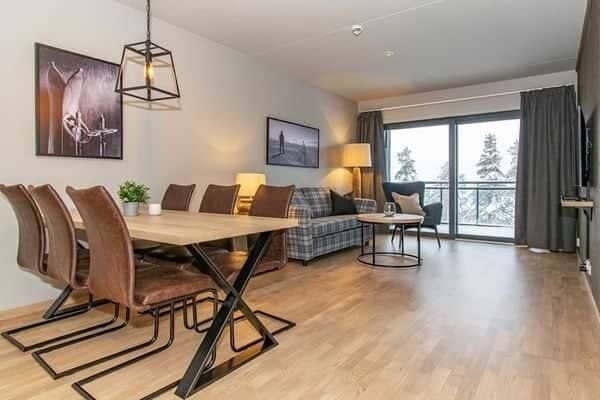 Open-plan living area with 6-seat dining table and balcony access