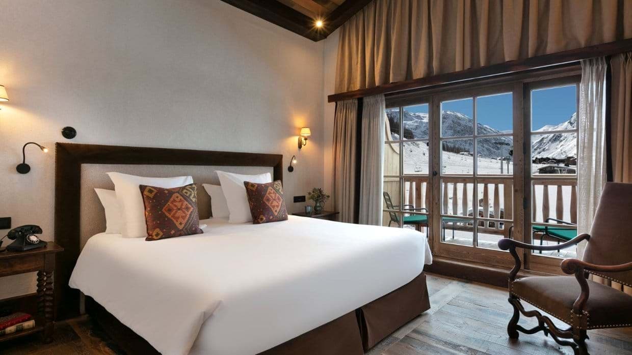 Bedroom with king bed and private balcony overlooking ski slopes