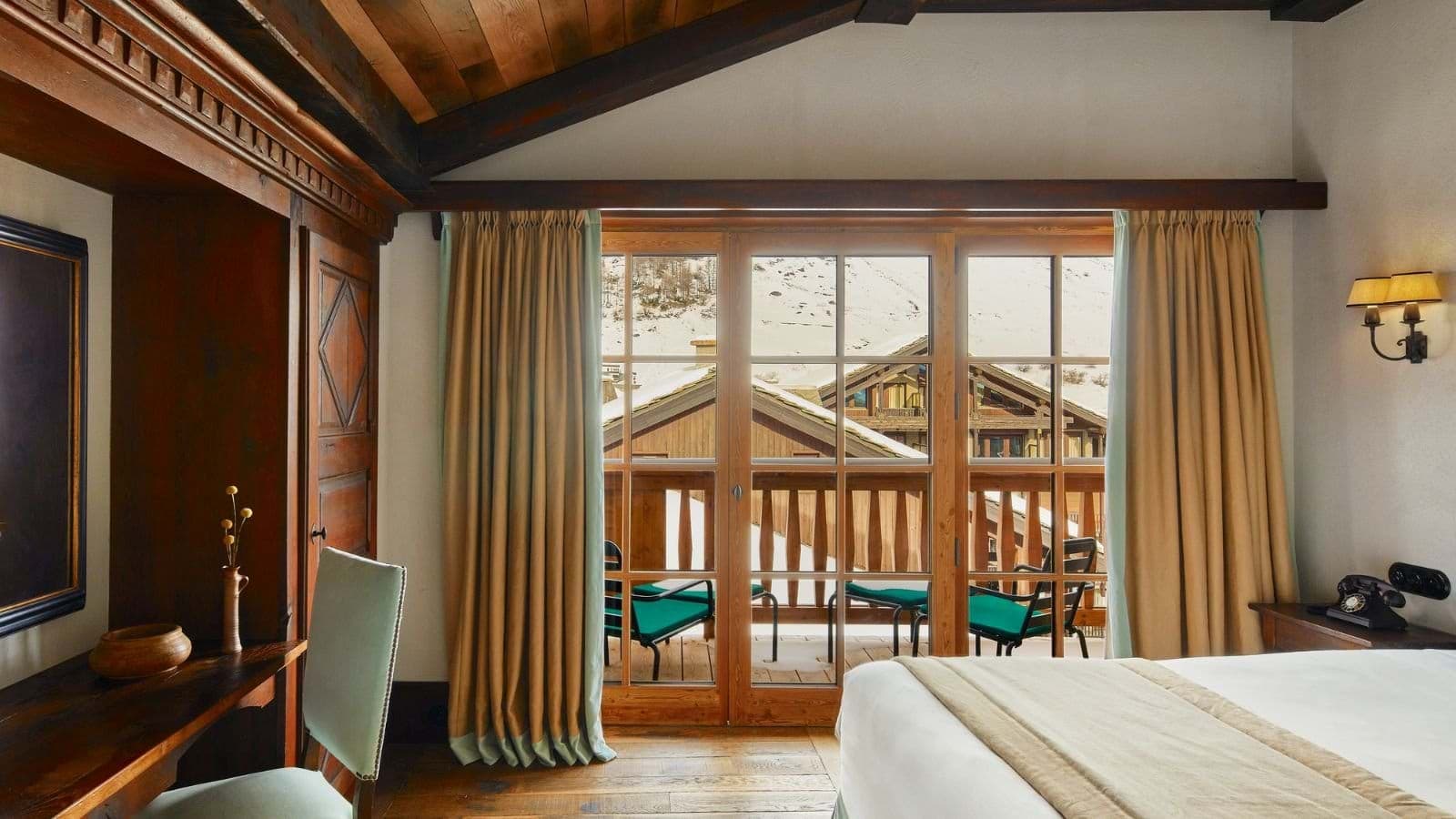 Bedroom with built-in desk, vaulted ceiling, and private balcony