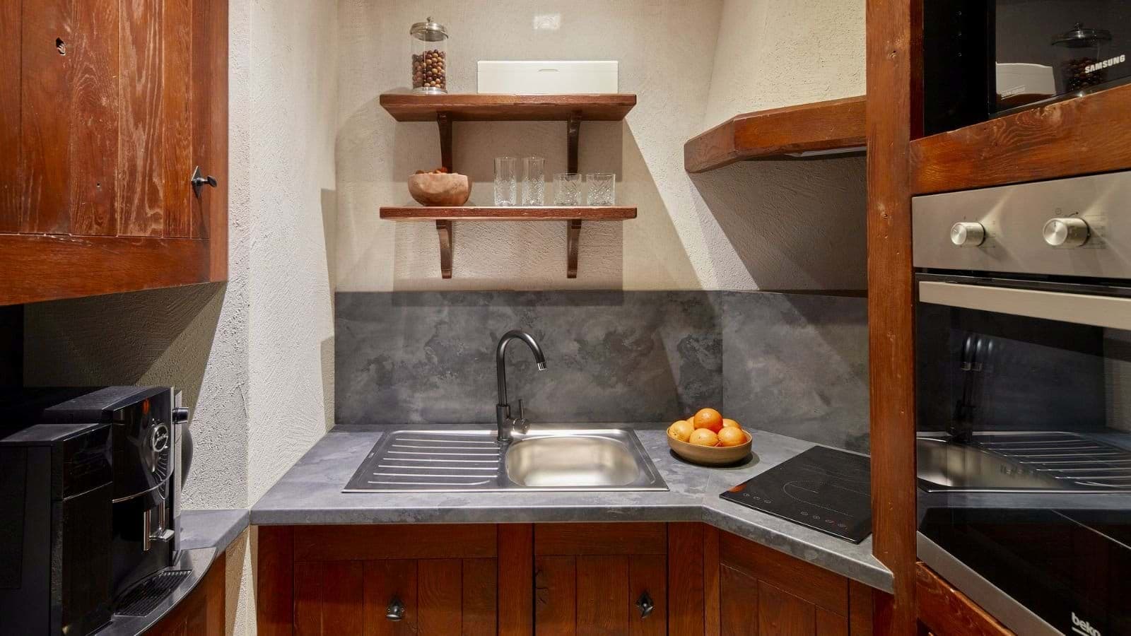 Kitchenette with two-burner cooktop, wall oven, and espresso machine