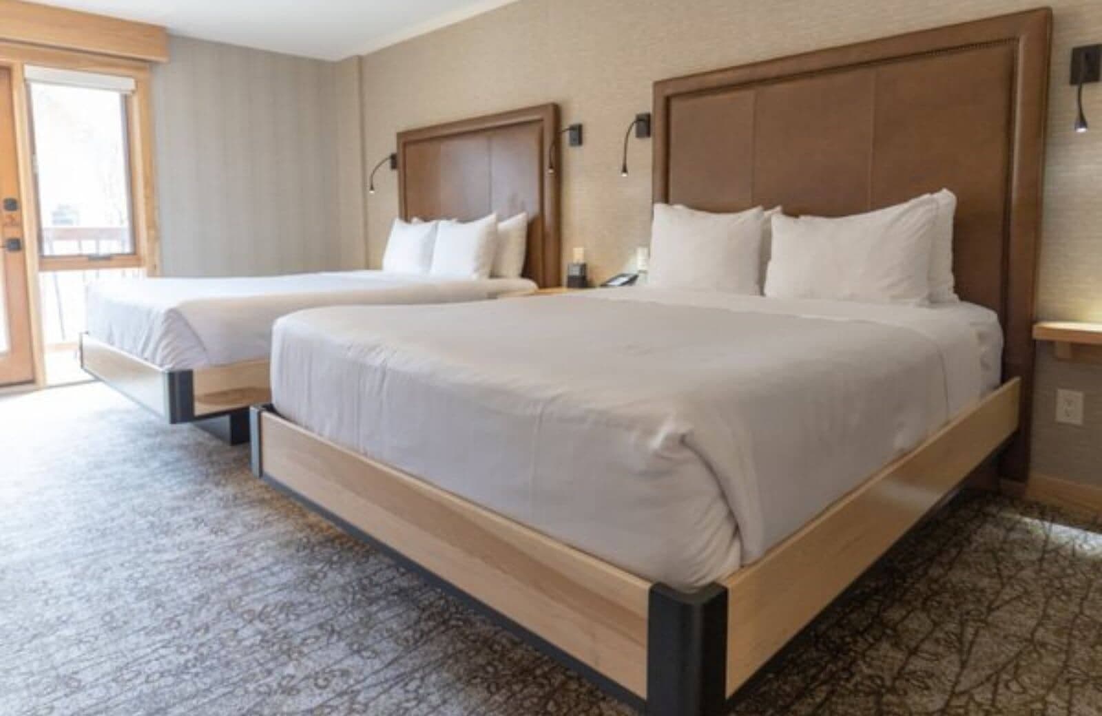 Guest bedroom with two queen beds and balcony access