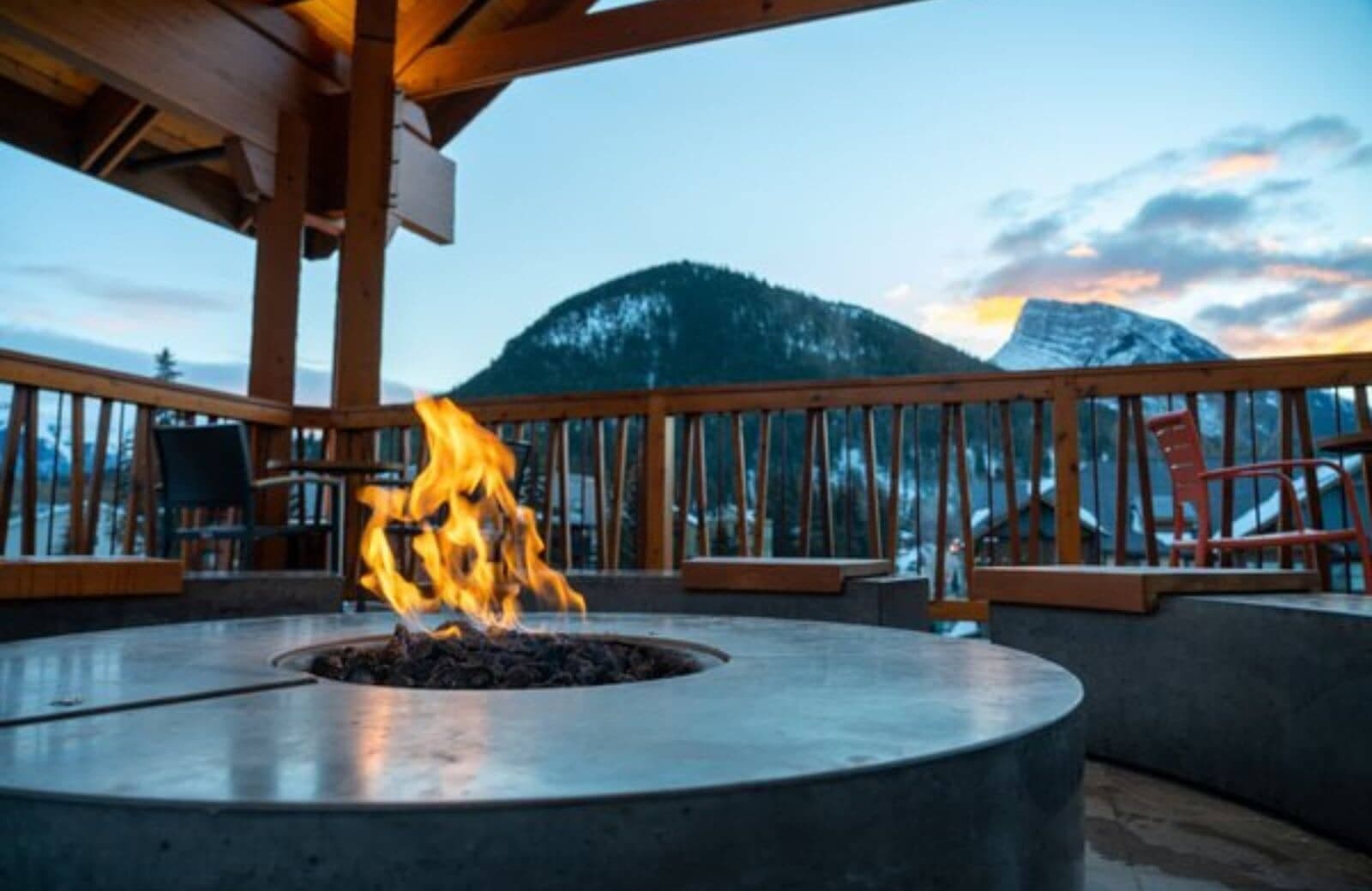 Outdoor gas fire pit with built-in bench seating and mountain views
