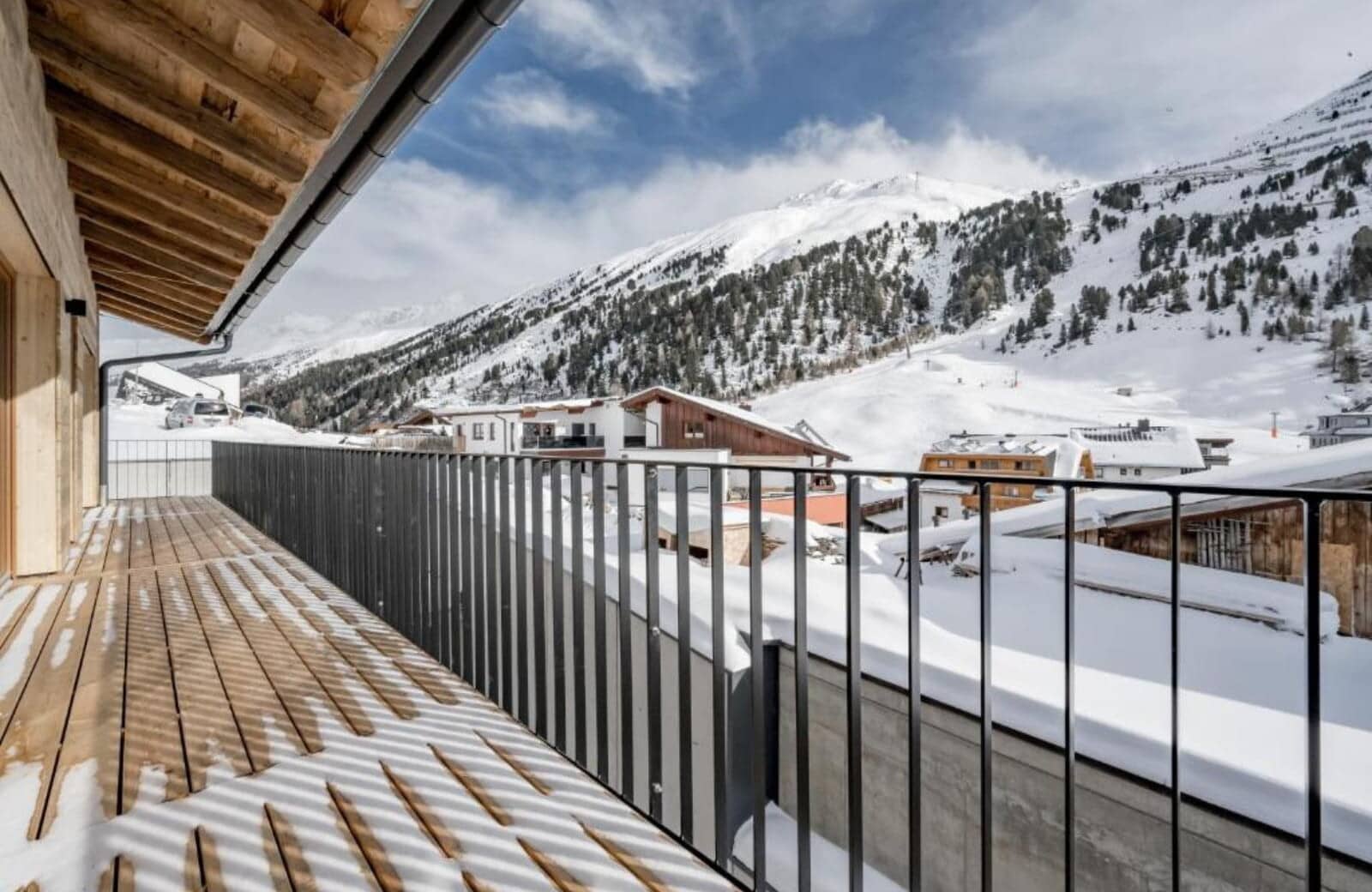 Covered balcony with wood-slat flooring and mountain views