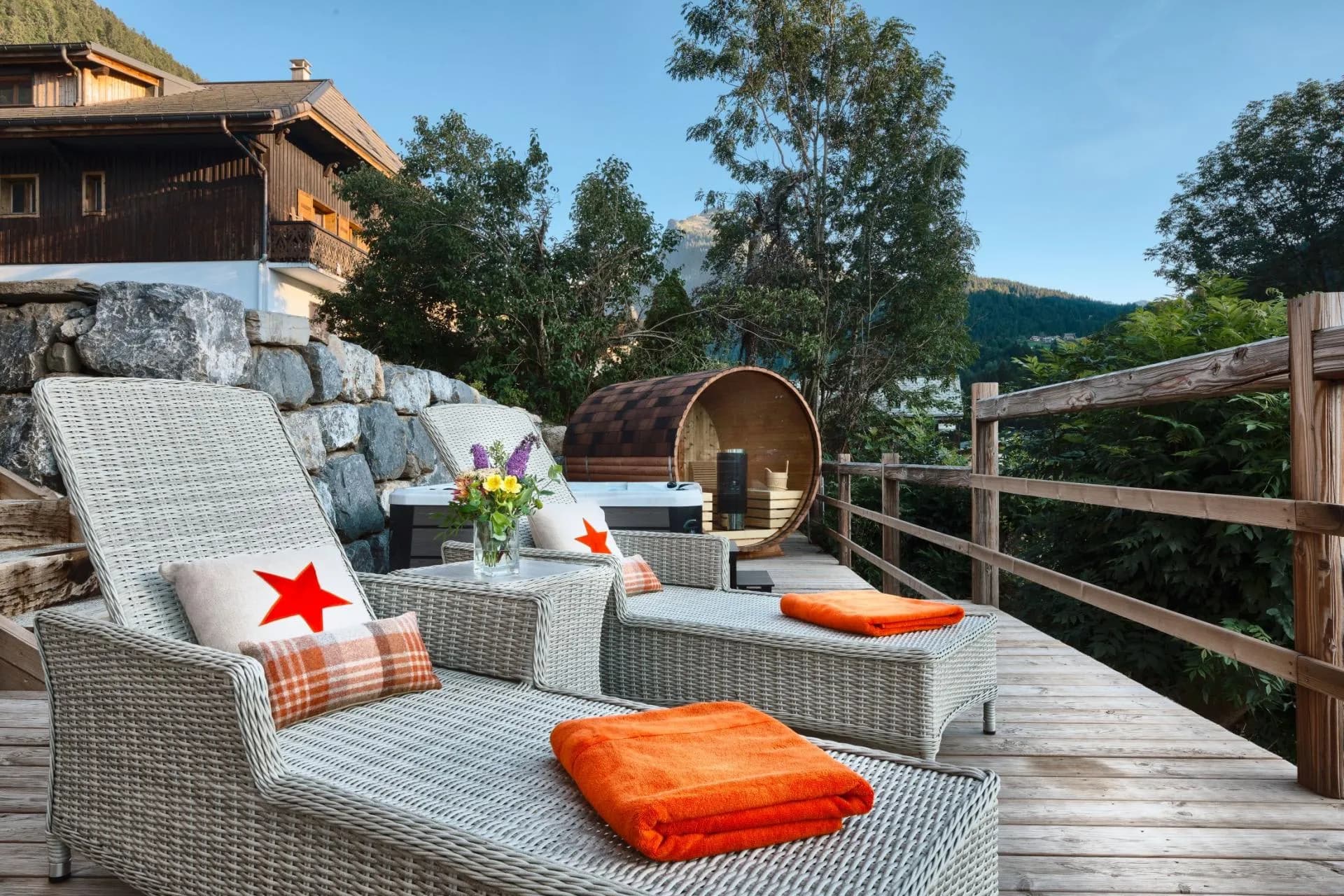 Outdoor sun deck featuring loungers, hot tub, and wood-fired barrel sauna