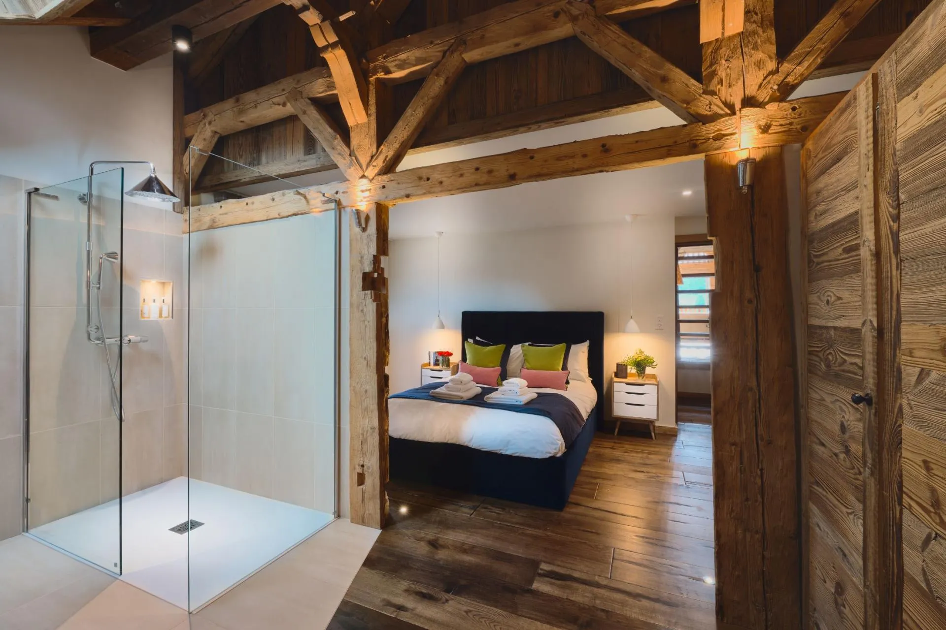 Open en-suite shower and dressing area beside a book-themed bedroom