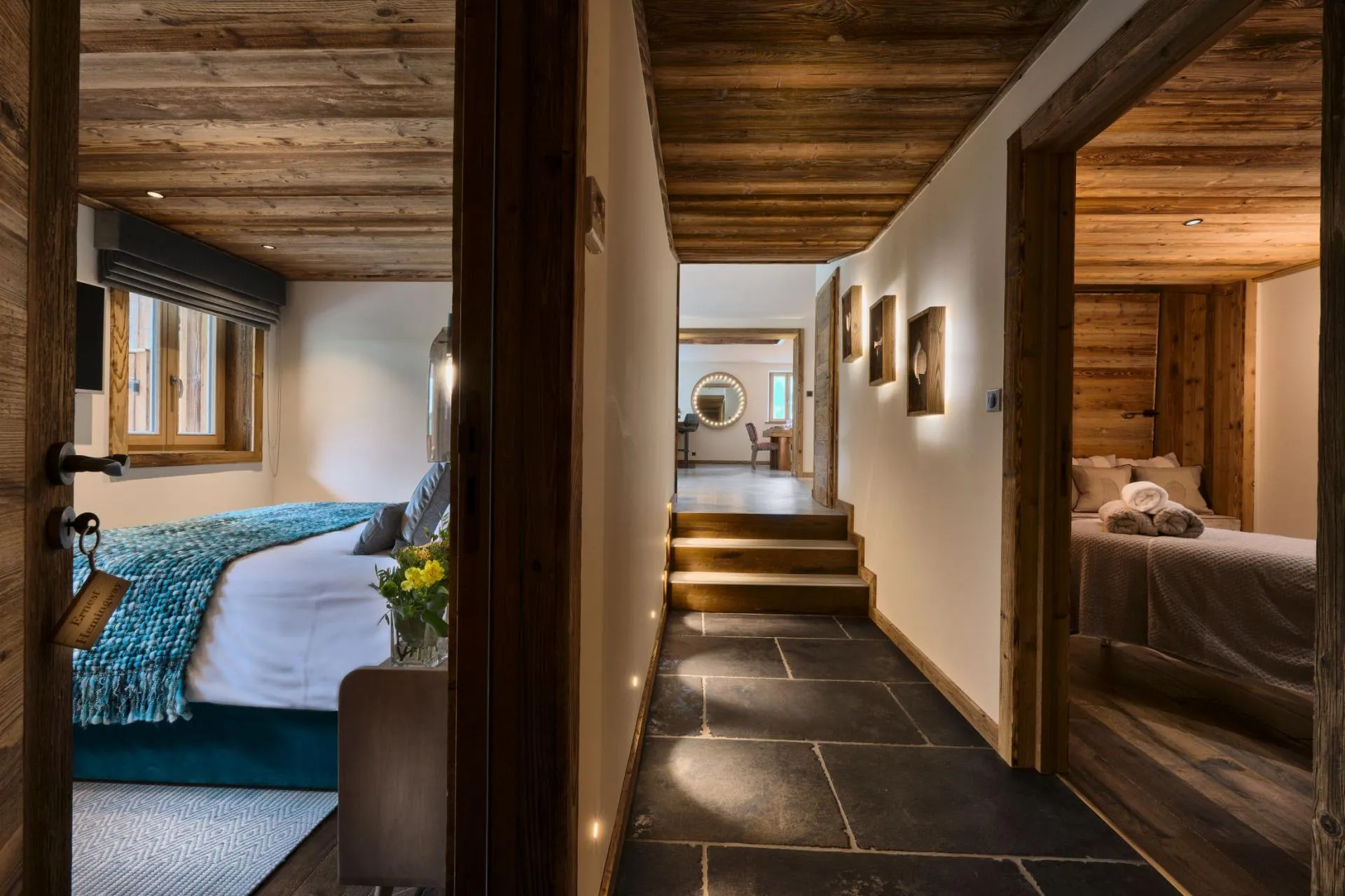 Hallway connecting two guest bedrooms with slate flooring and stair access