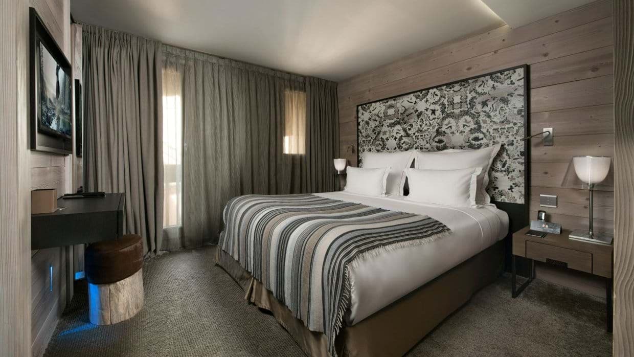 Bedroom with king bed, wall-mounted TV, and small desk area