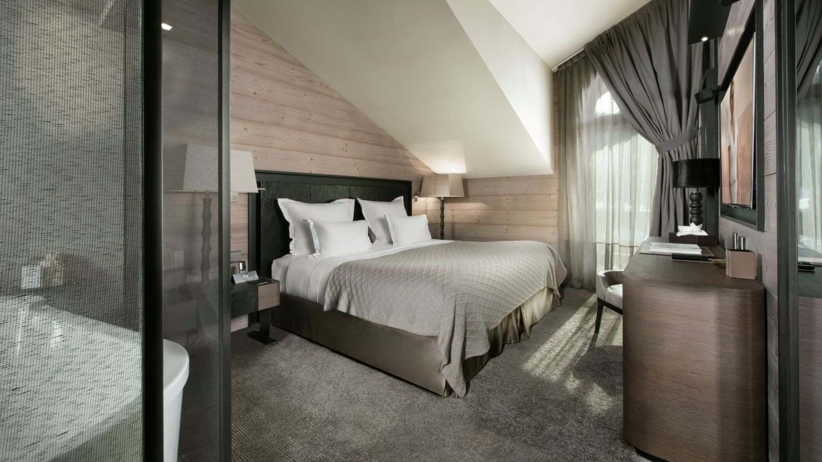 Bedroom with king bed and glass-walled ensuite bathroom