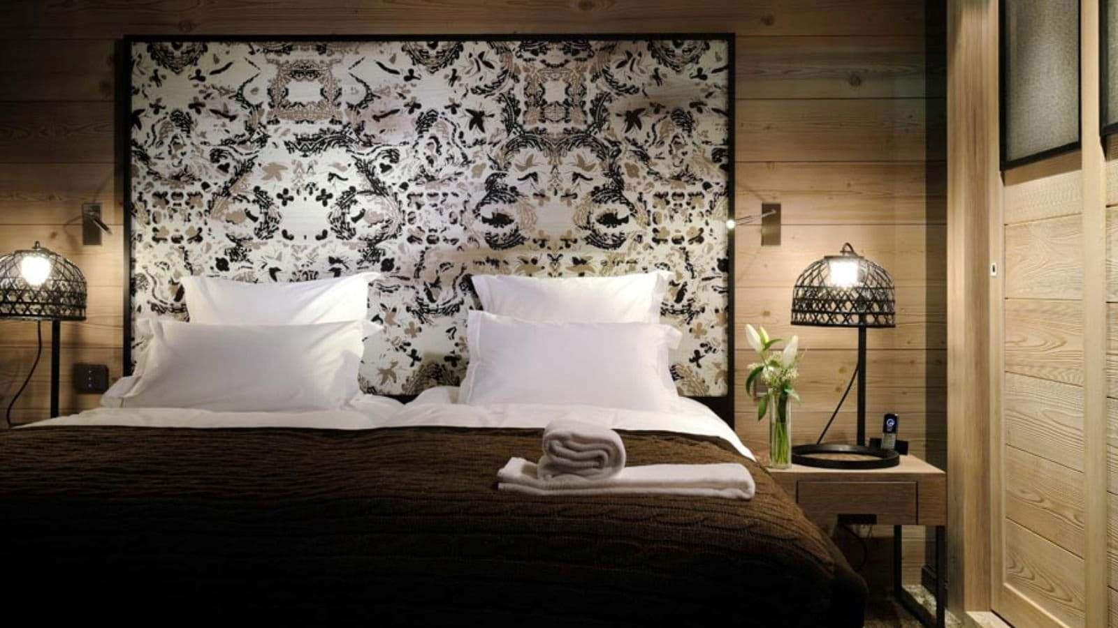 King bed with patterned headboard and integrated reading lights