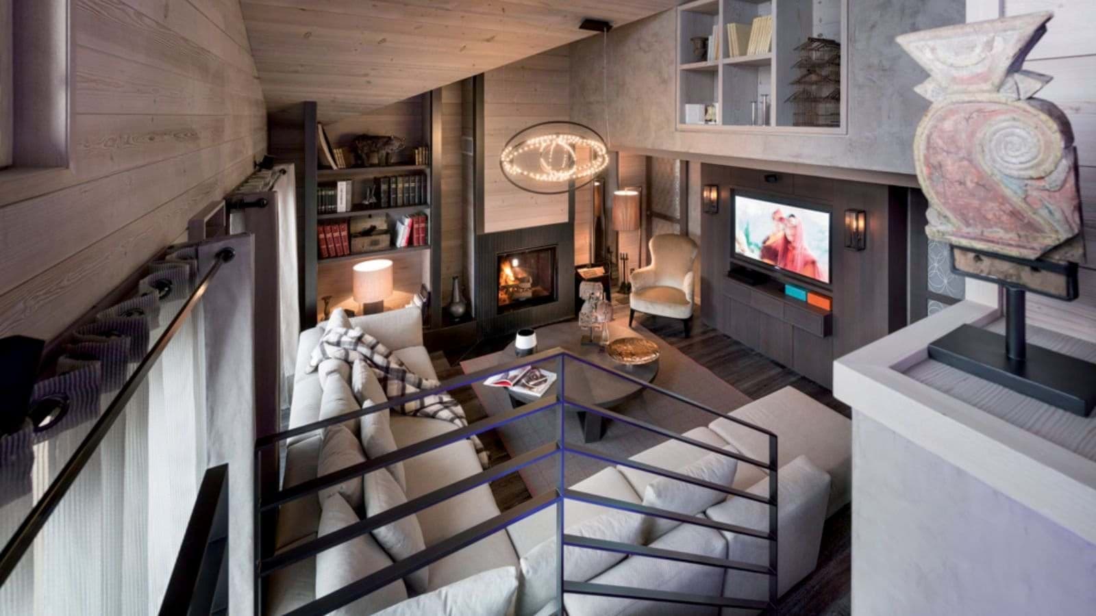 Living area with wood-burning fireplace, sectional seating, and built-in library