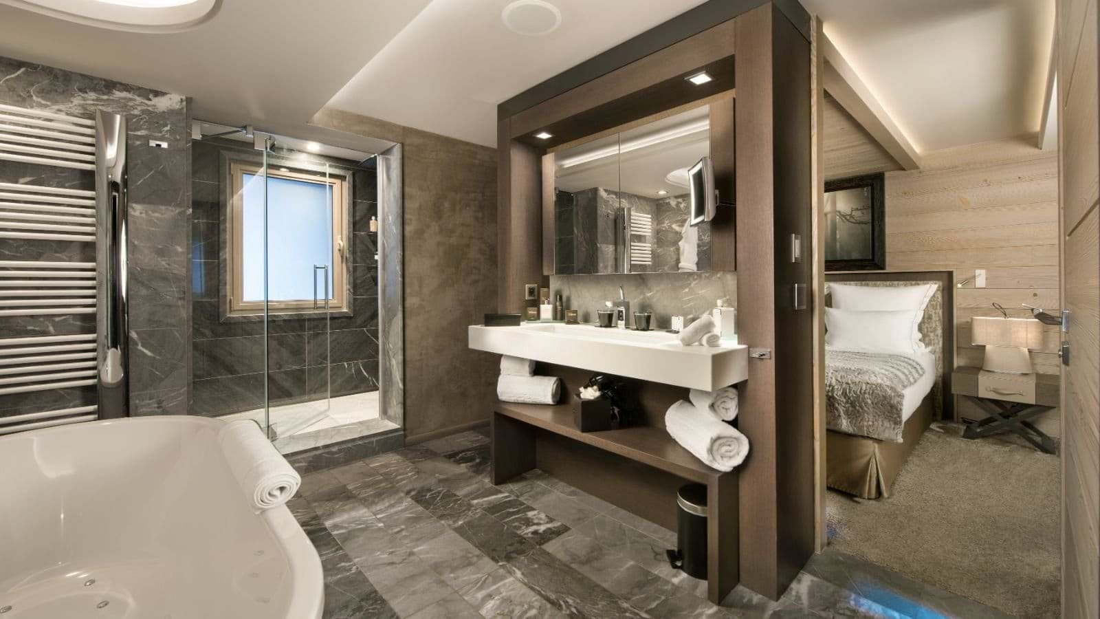 En suite bathroom with soaking tub, walk-in shower, and heated towel rail