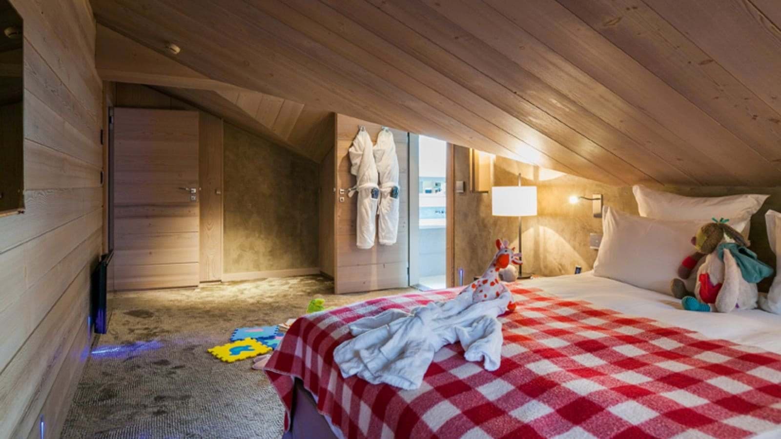 Attic bedroom with sloped timber ceilings and ensuite access