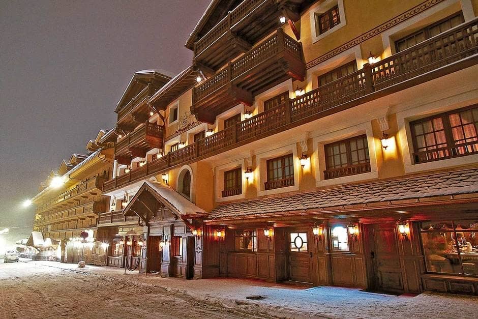 Chalet exterior at night with private balconies and ground-floor dining