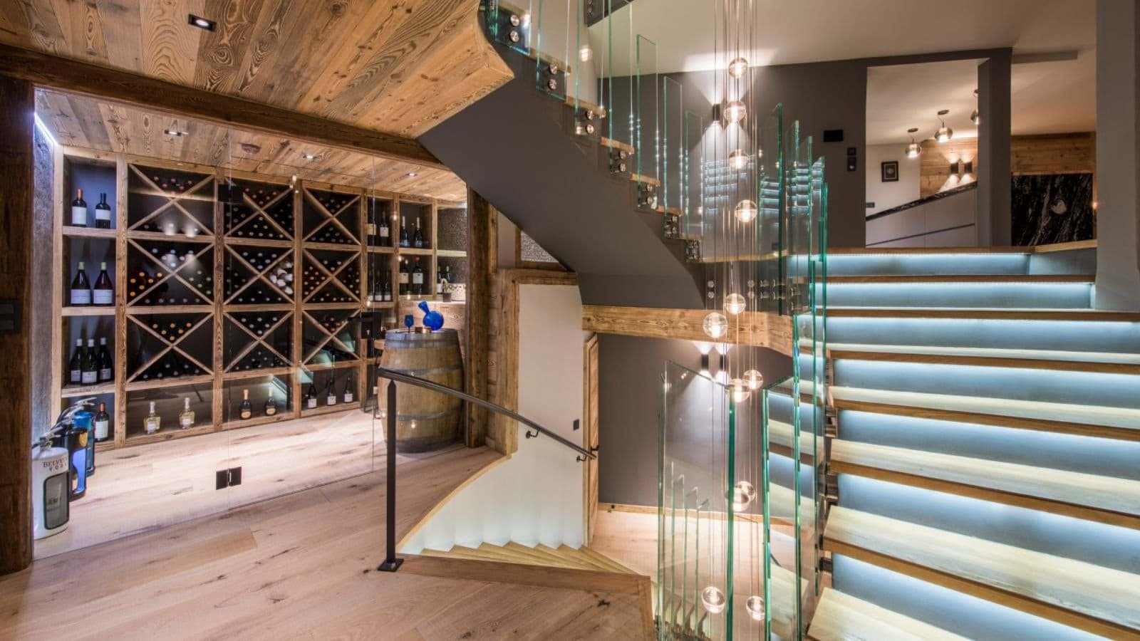 Glass-enclosed wine cellar and staircase with integrated LED tread lighting