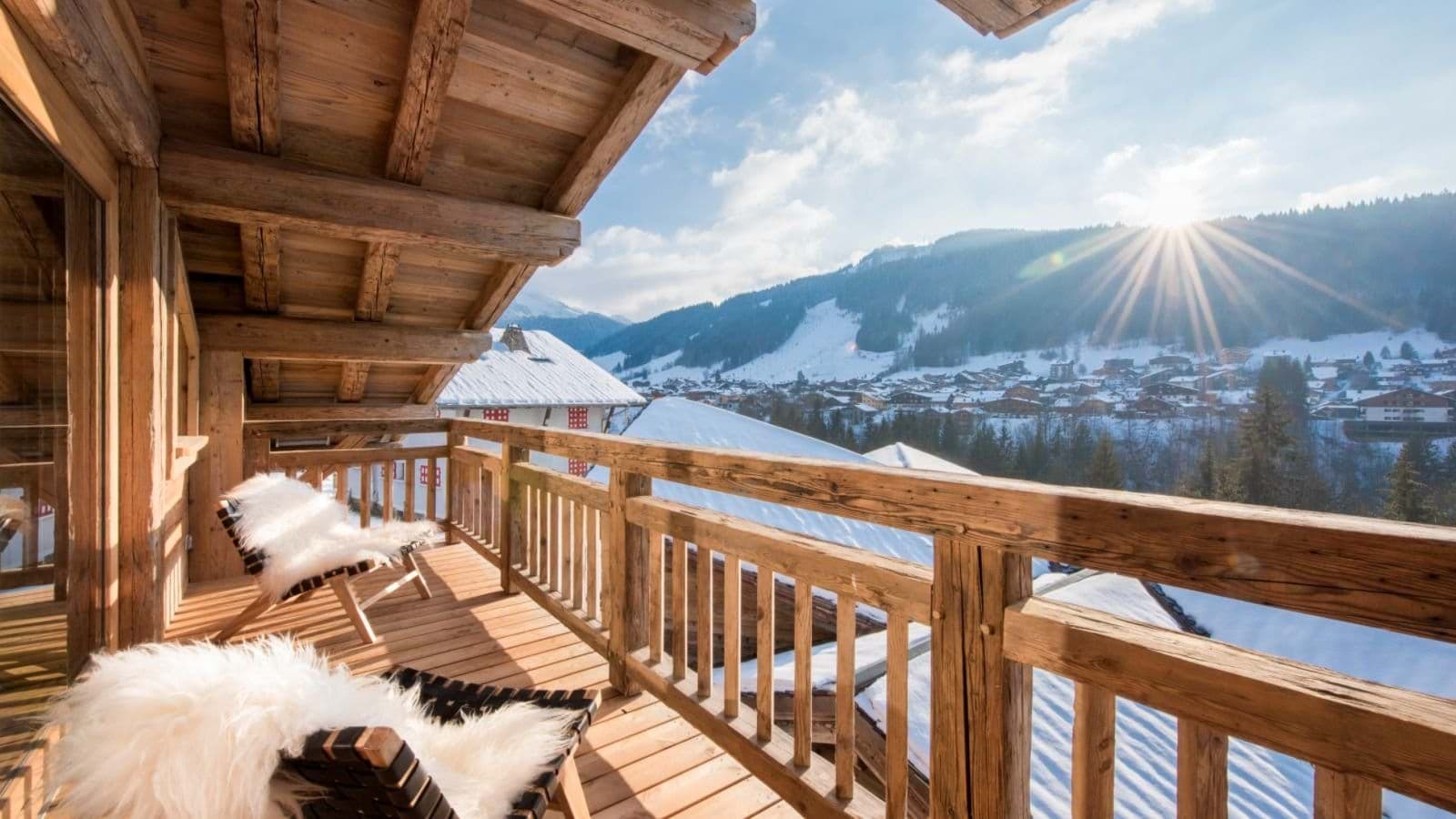 Wooden balcony with lounge chairs and views of the ski slopes