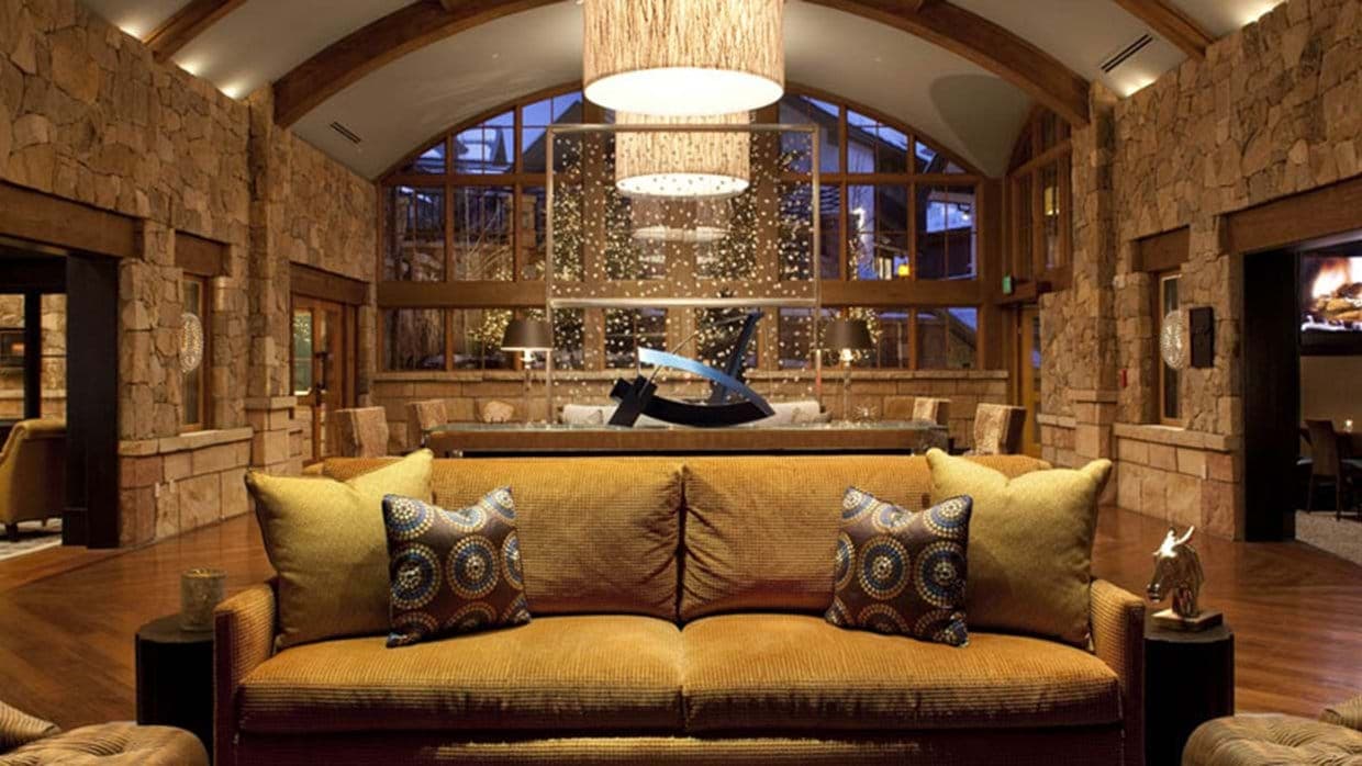 Great room featuring vaulted ceilings and floor-to-ceiling stone walls