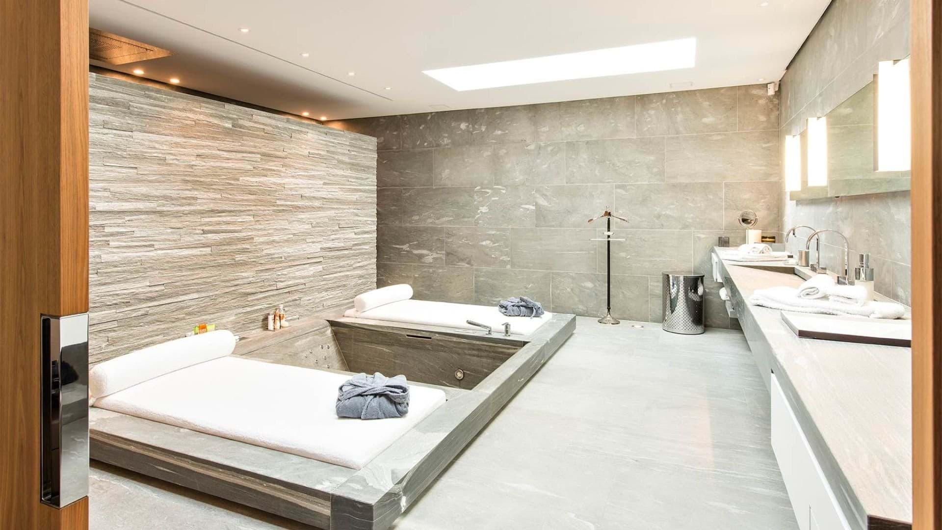 Spa bathroom with dual sunken tubs and skylight