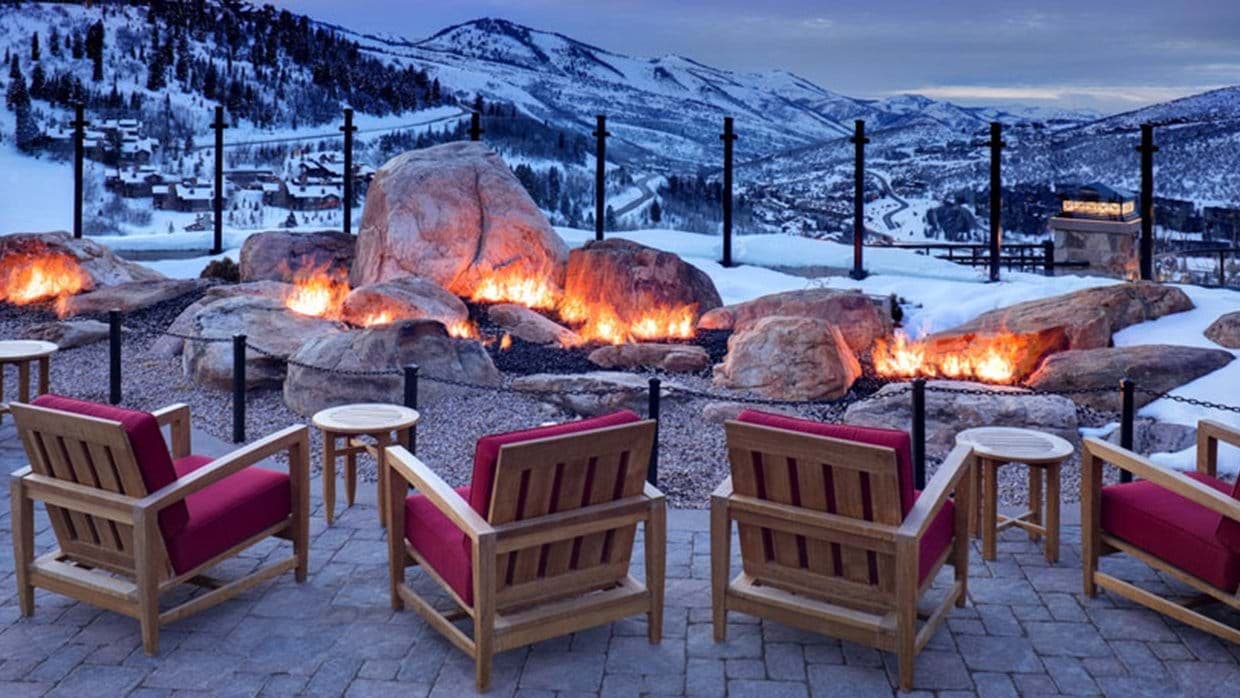 Outdoor patio with rock fire pit and panoramic mountain views