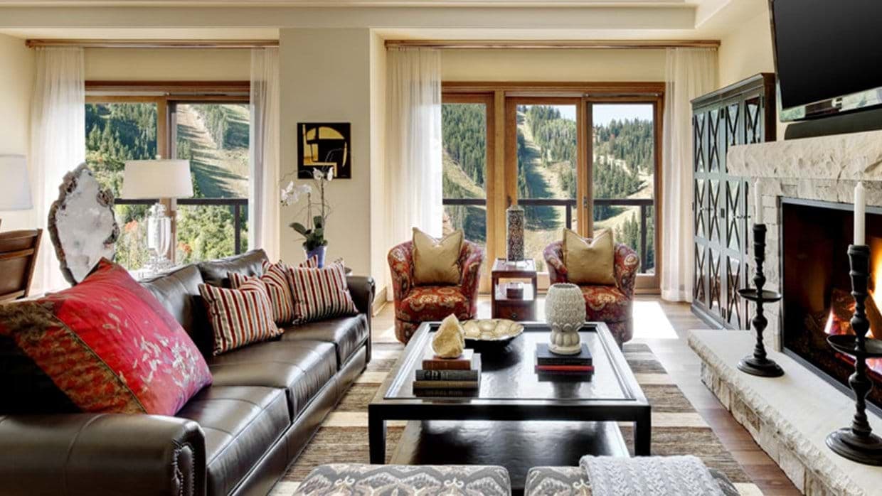 Living room with stone fireplace and views of ski trails