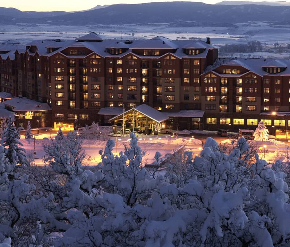 Mountain resort at dusk with covered entrance and valley views