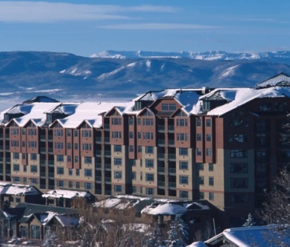 Resort exterior featuring private balconies and snow-capped mountain views