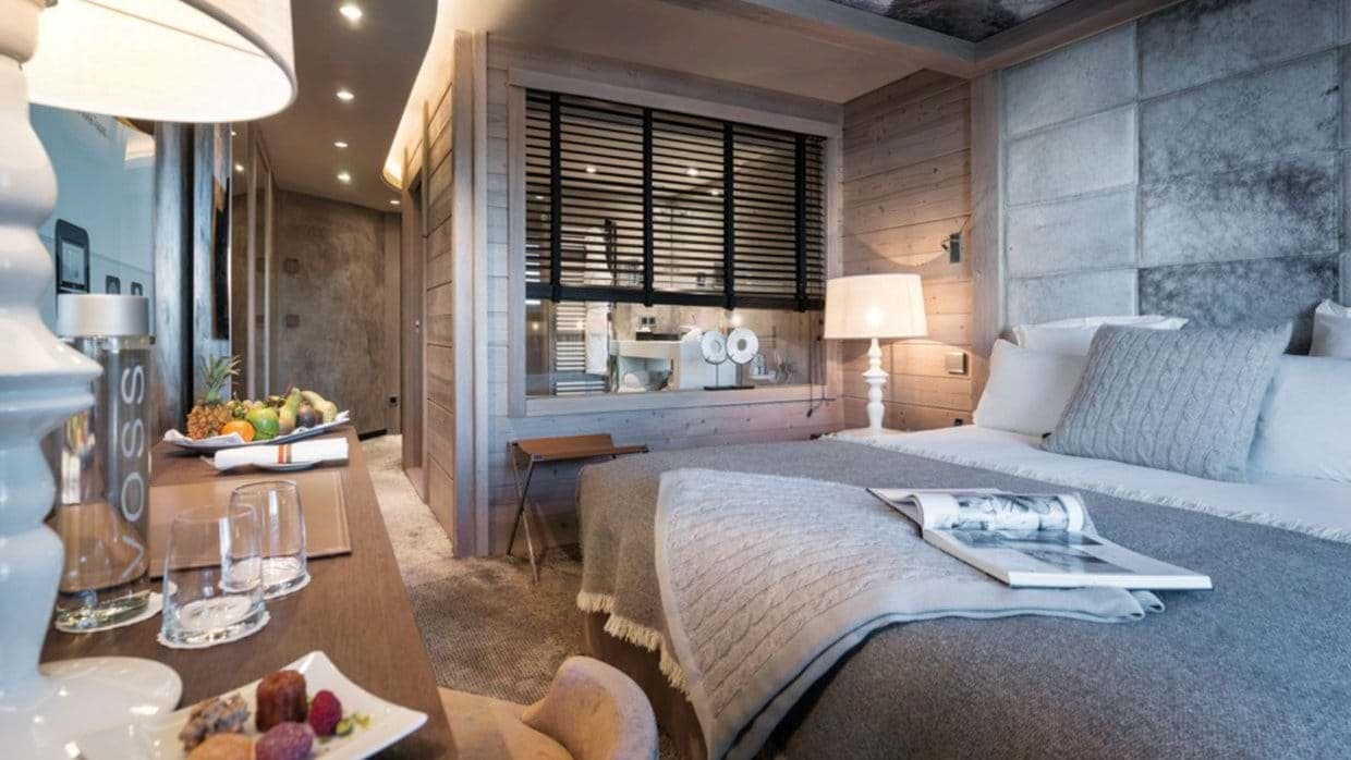 Primary bedroom with wood paneling and internal window to ensuite bathroom