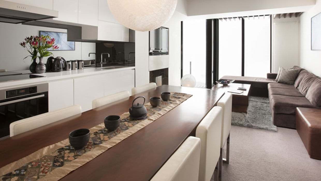 Open-plan living area with 6-seat dining table and kitchenette