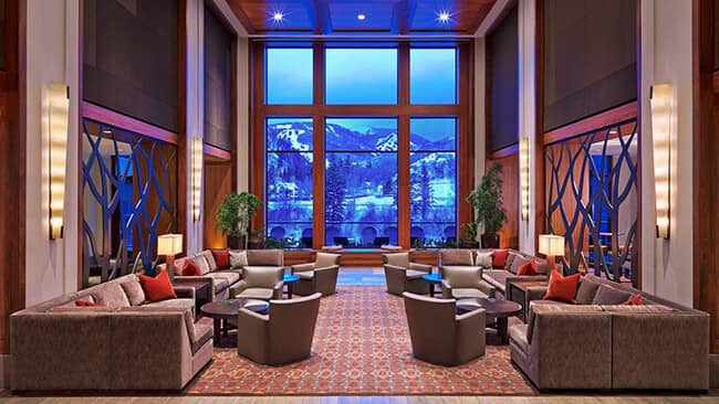 Lounge area with sectional seating and floor-to-ceiling ski mountain views