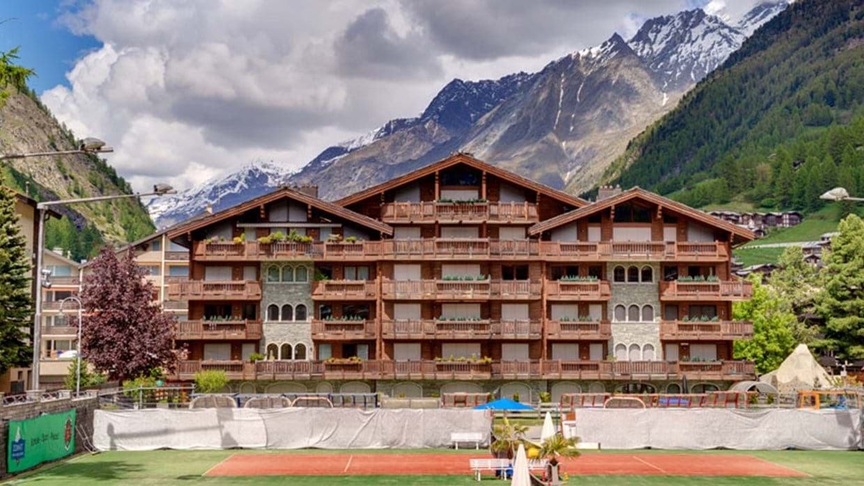 Chalet-style apartment building with tennis courts and mountain views