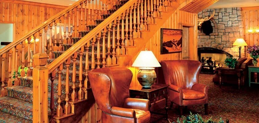 Lobby lounge with leather wingback chairs and wood-burning stone fireplace