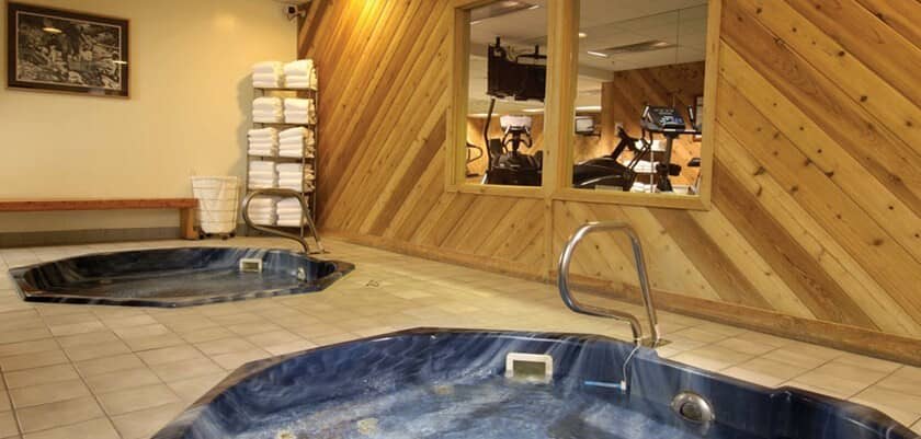 Shared spa area with dual indoor hot tubs and adjacent fitness center