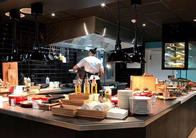 Commercial-grade kitchen with open service counter and industrial exhaust hood