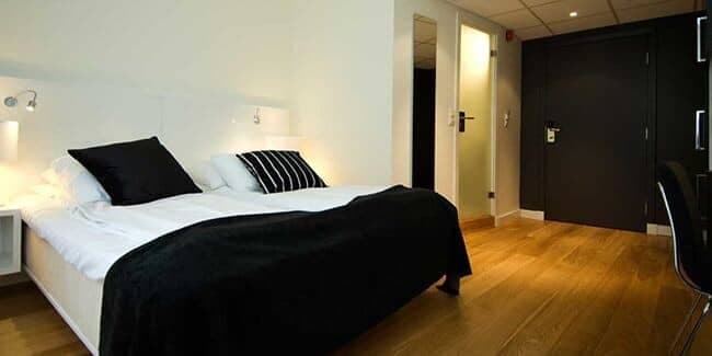 Guest bedroom with queen bed, hardwood floors, and dedicated workspace