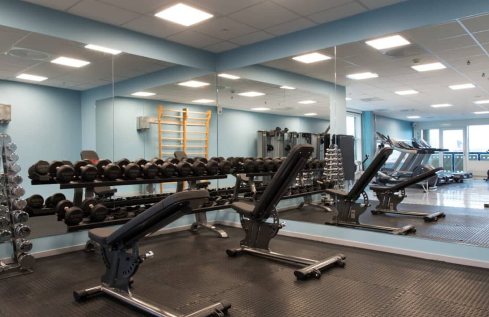 Fitness center with free weights, adjustable benches, and cardio machines