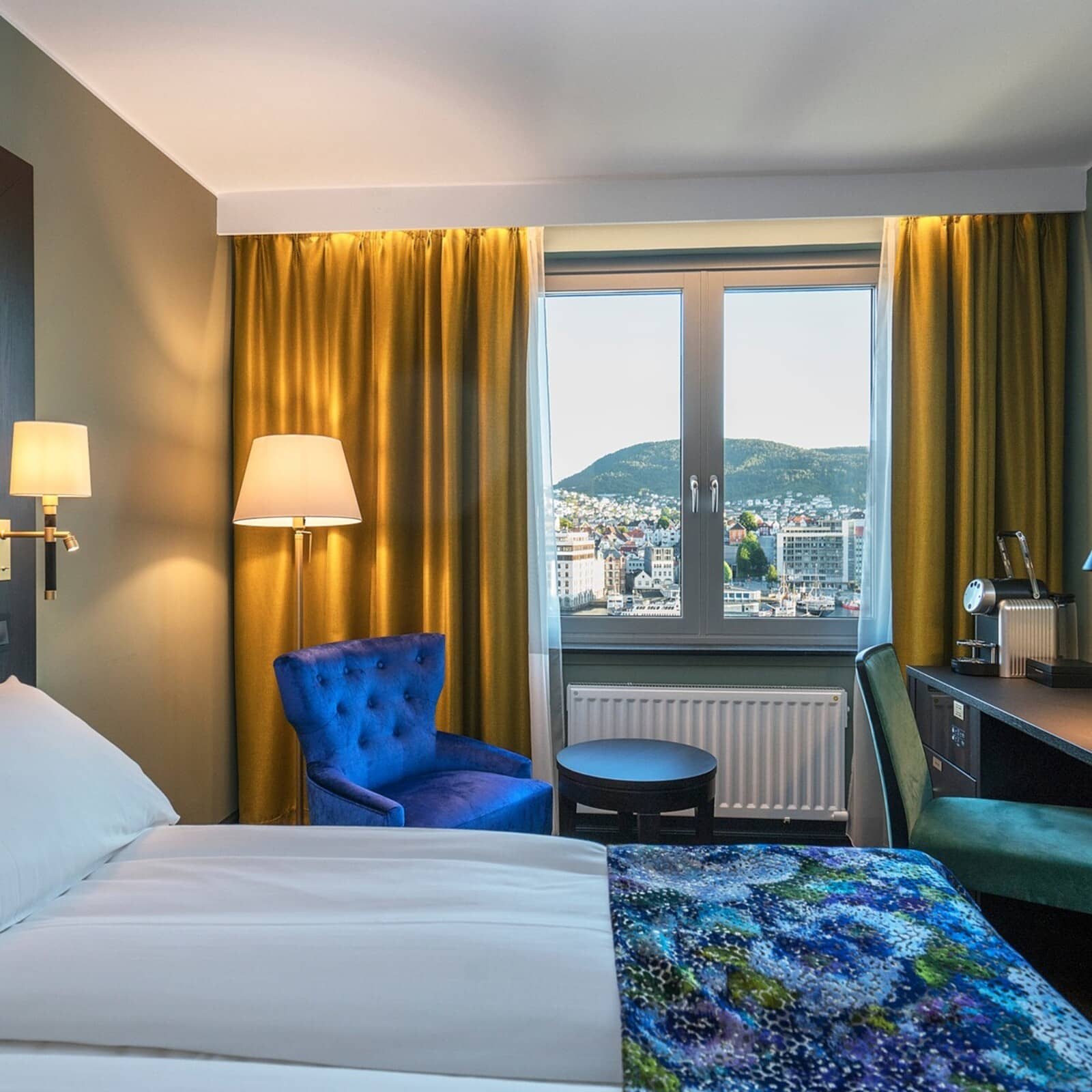 Guest bedroom with dedicated workspace, Nespresso machine, and harbor views
