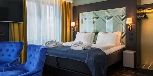 Guest bedroom with king bed, open closet, and wall-mounted TV