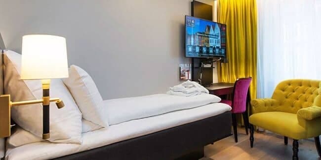 Guest bedroom with single bed, armchair, and dedicated workspace