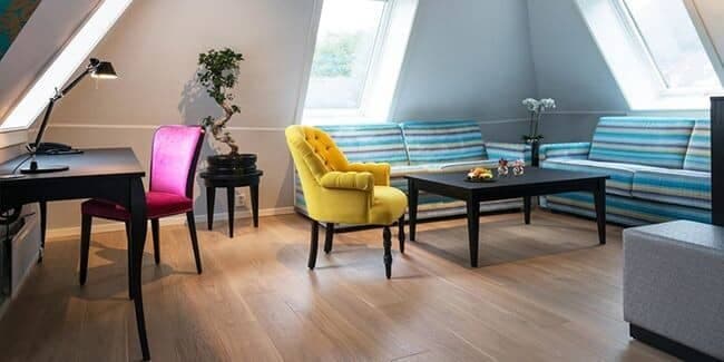 Attic living area with dedicated workspace and skylight windows