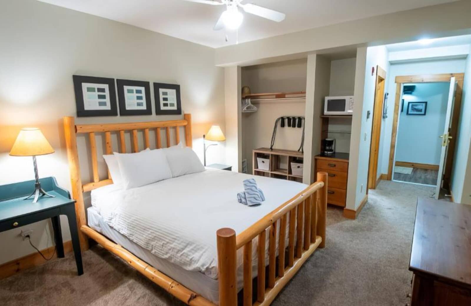 Guest bedroom with log-frame queen bed and private kitchenette nook