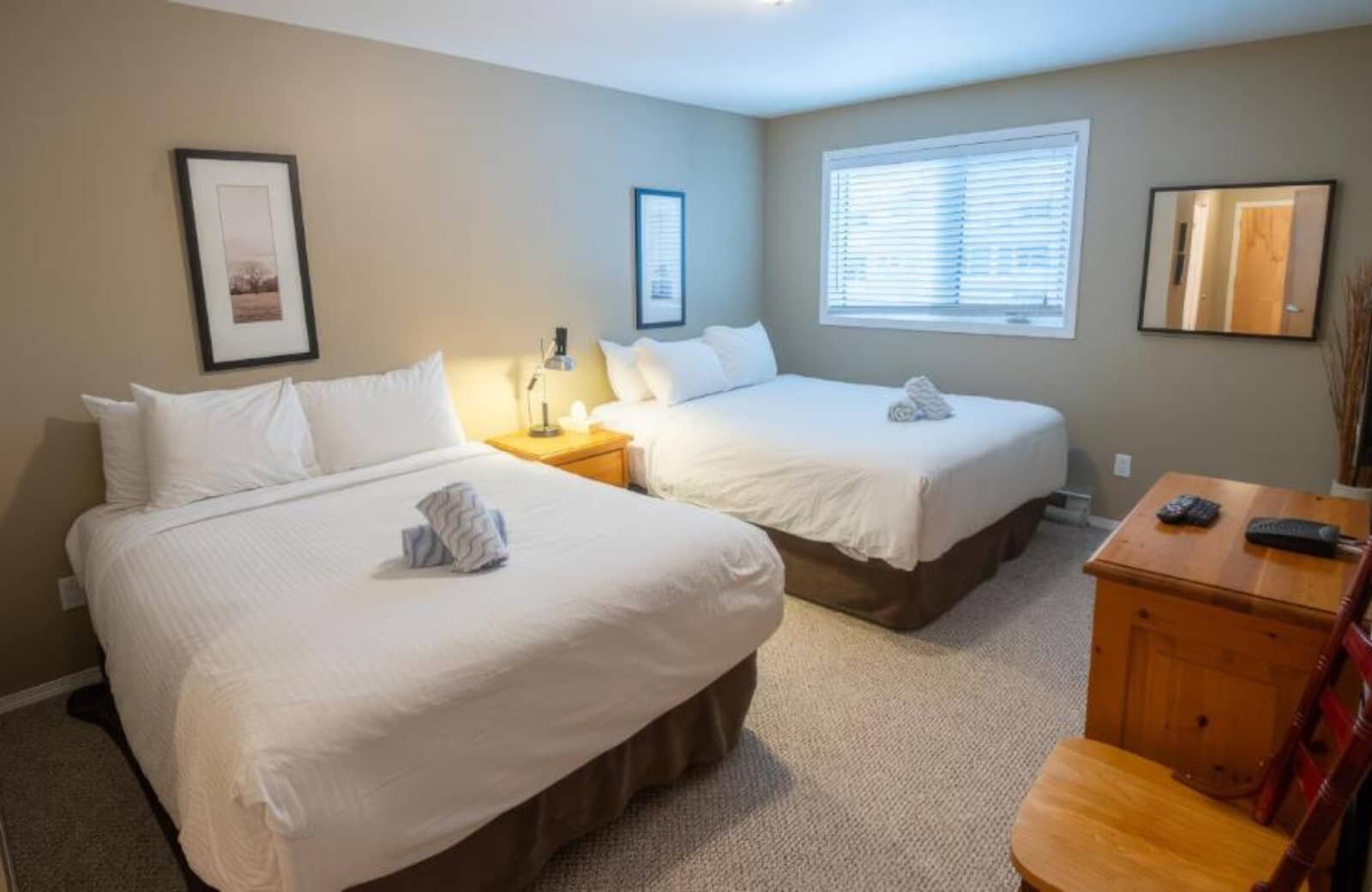 Guest bedroom with two queen beds and wooden dresser