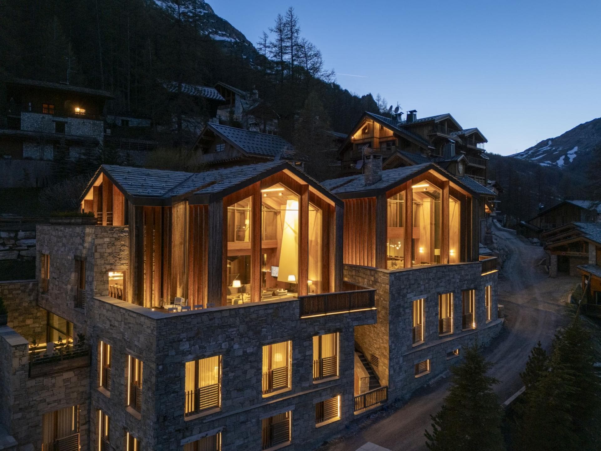 Stone and timber chalet exterior with floor-to-ceiling windows and terrace