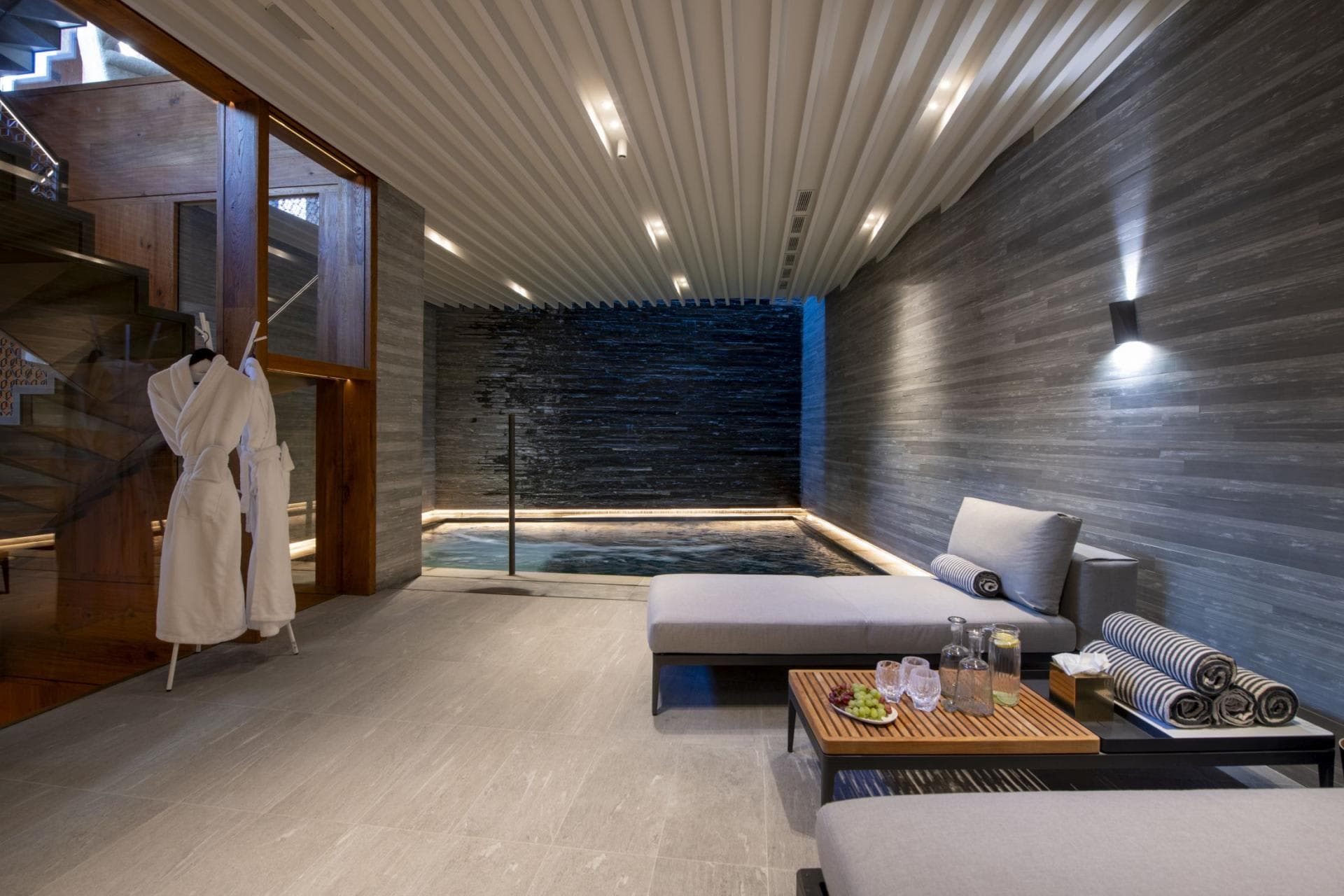 Indoor spa with heated plunge pool and stone water feature