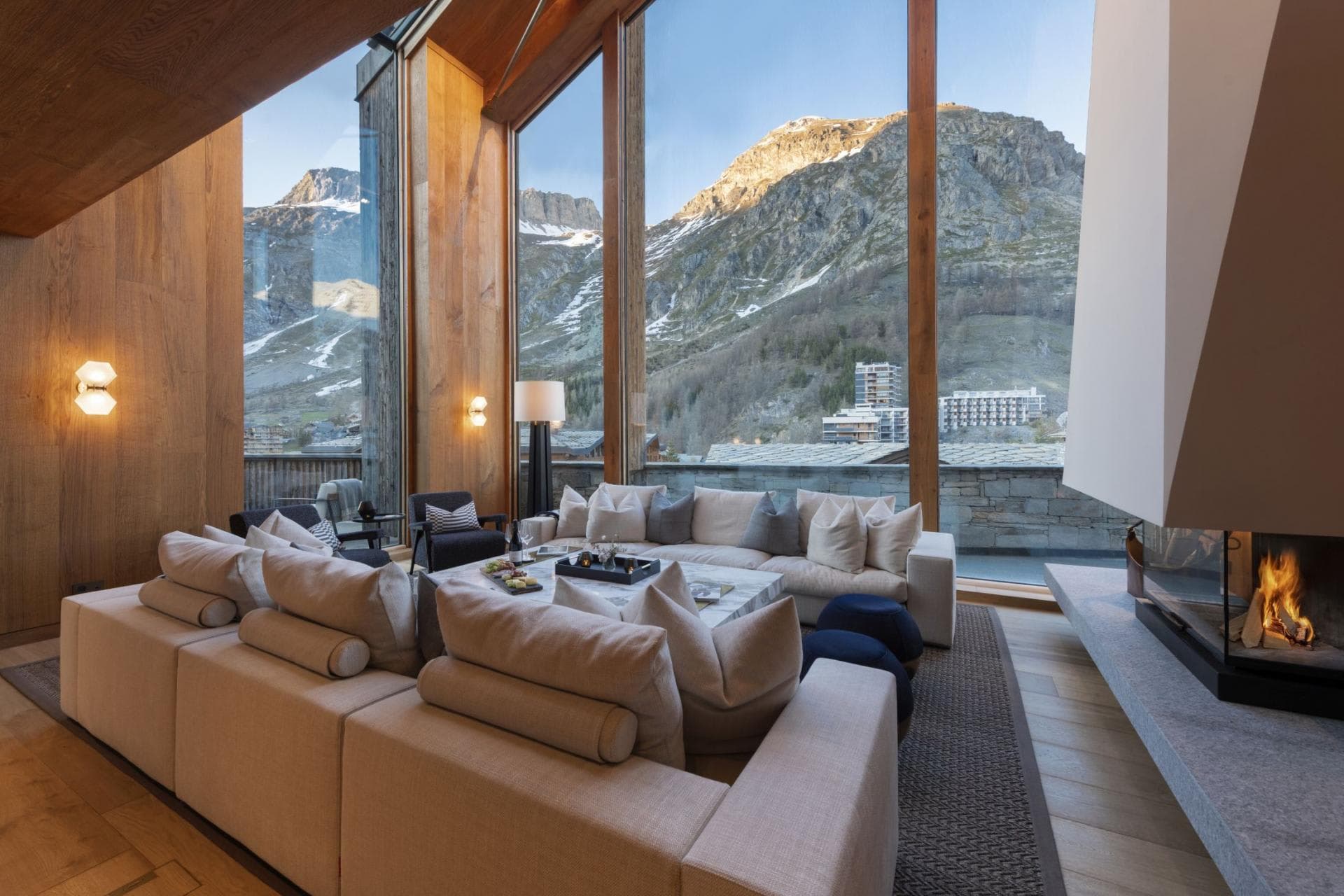 Living area with wood-burning fireplace and floor-to-ceiling mountain views